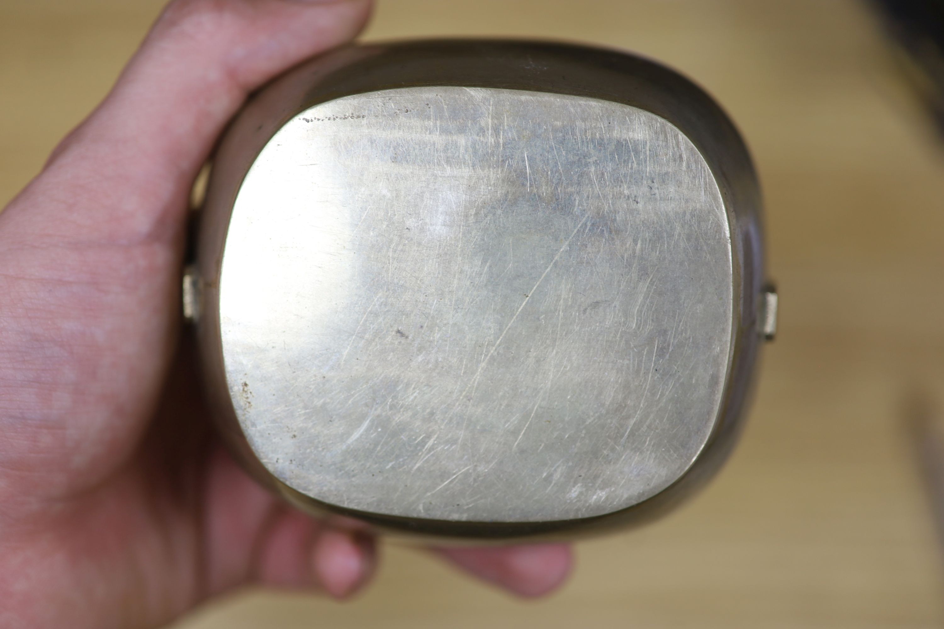 A Chinese lacquer and composition dish and a bronze hand warmer, length 27cm